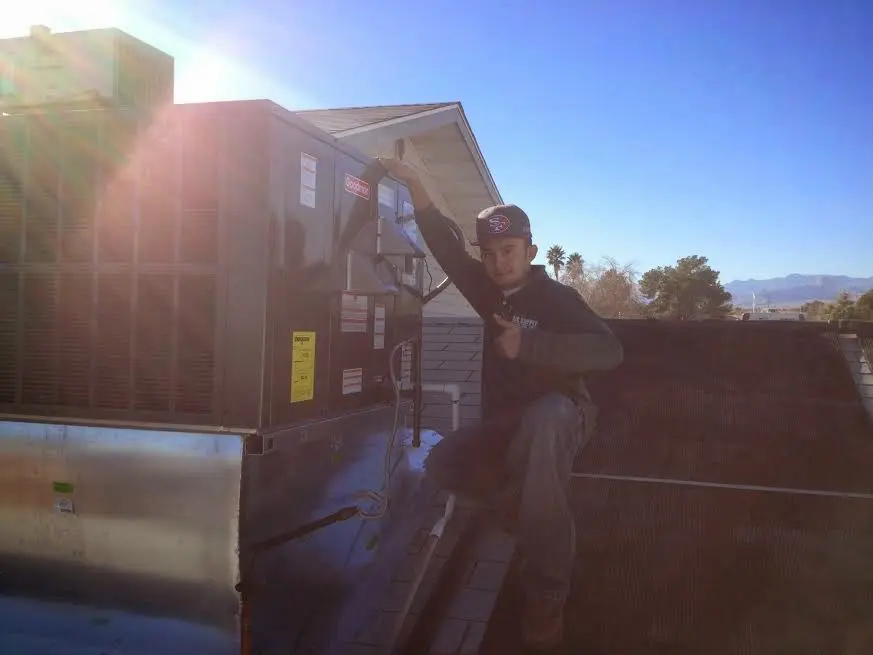 HVAC technician performing AC Tune-Up on a rooftop unit in Port Chester